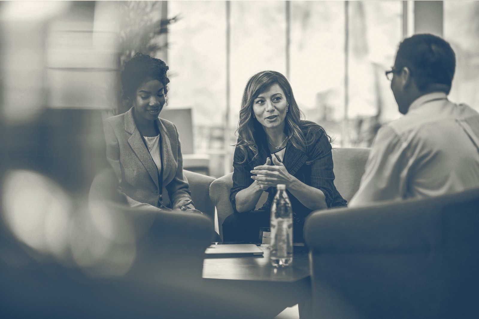 Adviser talking through documents with clients at a meeting room table